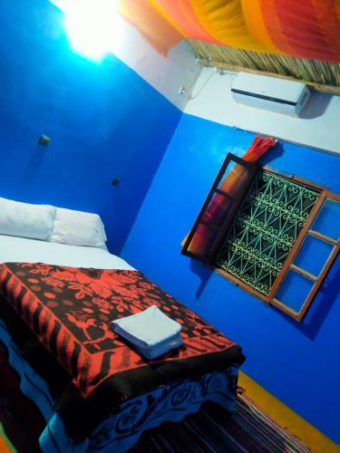 a blue room with a bed and a window at Luna del fuego in Ifri