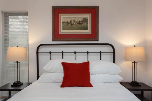 a bedroom with a bed with a red pillow and two lamps at Hendo Hideaway A 2bed/1bath in Hendersonville