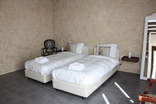 deux lits dans une chambre avec des draps blancs dans l'établissement Gîte Chevannes, à Fours