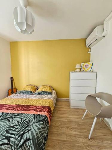 a bedroom with a bed and a dresser and a chair at La BellaGeal - Charme & Confort in Schœlcher