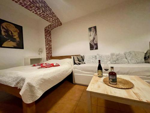 um quarto com duas camas e uma mesa com uma garrafa de vinho em Ubytování v soukromí Bělčice em Bělčice