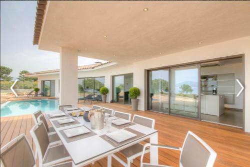 une salle à manger avec une table et des chaises et une piscine dans l'établissement Villa HAPPY DAYS, à Pietrosella
