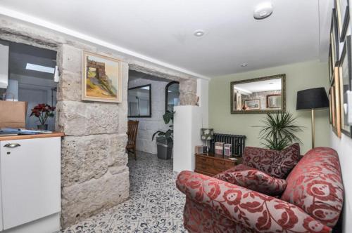 a living room with a red couch and a stone wall at Duke’s Cottage in Portland