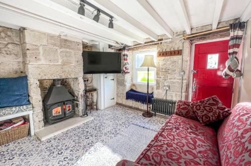a living room with a red couch and a stone fireplace at Duke’s Cottage in Portland