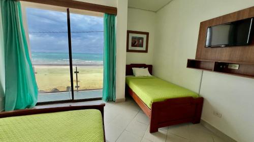 a bedroom with a bed and a view of the beach at Hotel Sierra Negra in Puerto Villamil