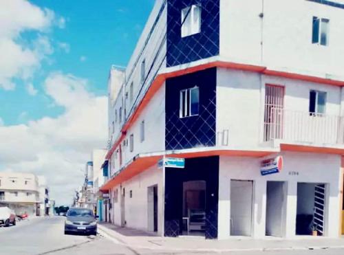 budynek na ulicy z samochodem zaparkowanym obok niego w obiekcie Hotel pousada sonho meu w mieście Arapiraca