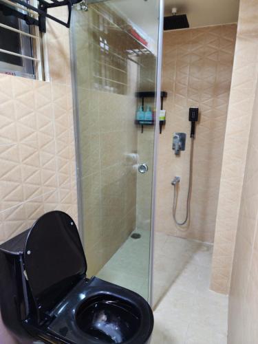 a bathroom with a toilet with a glass shower at Entire 1 BED ROOM Studio Apartment Uttara 14 in Dhaka