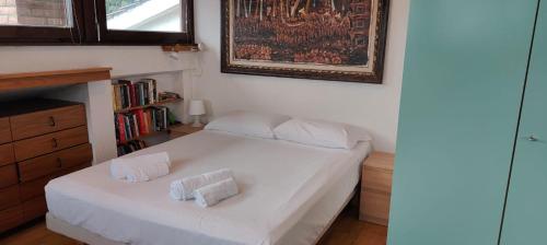 a bedroom with a white bed with two pillows on it at Locazione Turistica Via Del Pucino in Grljan