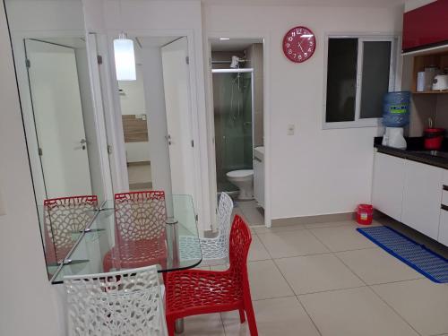 a kitchen with a glass table and red chairs at Apartamento 2 quartos May Way Meireles uma quadra da Beira-mar in Fortaleza