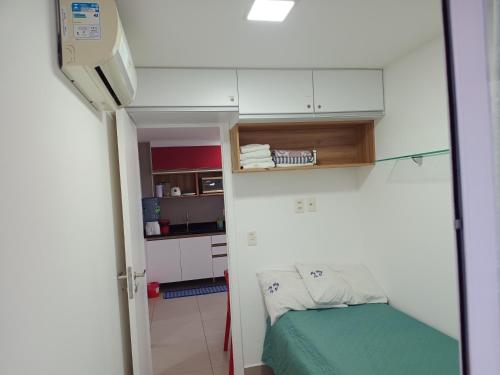 a small room with a bed and a small kitchen at Apartamento 2 quartos May Way Meireles uma quadra da Beira-mar in Fortaleza