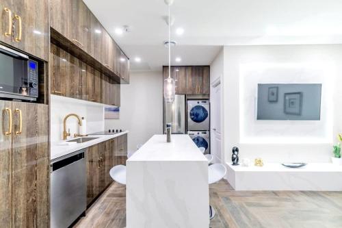 uma cozinha com um balcão branco e armários de madeira em Luxury 2BR Unit - Heart of the Chinatown em Toronto