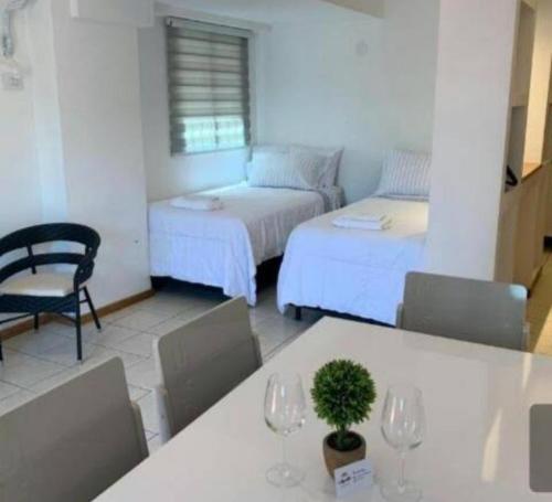 una habitación con 2 camas y una mesa con copas de vino en Alquileres Temporarios Darío en Maipú