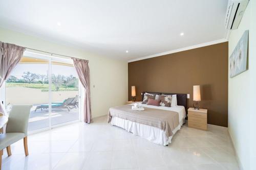 een slaapkamer met een groot bed en een balkon bij Casa Ferrel - Luxury 9 Bedroom Villa with Indoor & Outdoor Pools in Lagos