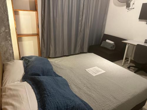 a bedroom with a bed with a blue blanket on it at Hotel Casa Lucca in Medellín