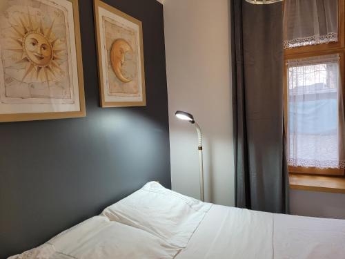 トルンにあるKlimatyczny apartament na starówceのベッドルーム1室(ベッド1台、ランプ、窓付)