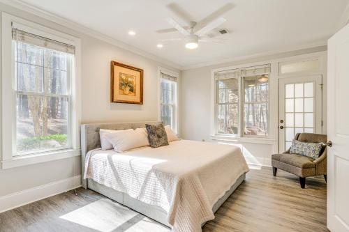 a bedroom with a bed and a chair and windows at Chic Greensboro Condo with Lake Oconee Access! in Greensboro