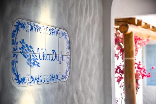 a blue and white plate on a wall with a mirror at Vila DuJu in Porto De Galinhas