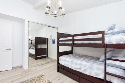 a bedroom with two bunk beds and a mirror at 6 Bedroom Remodeled Home on the Oceanfront in Newport Beach