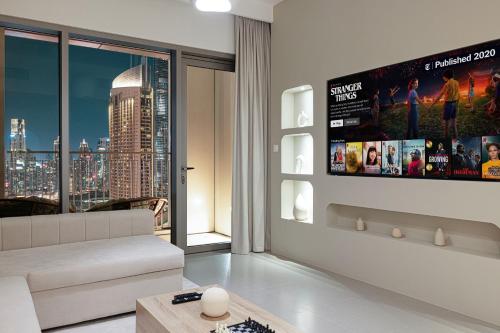 a living room with a couch and a flat screen tv at Burj Khalifa View, High Floor, Dubai Mall Access, Gym, Infinity-Pool, Playground, BBQ, Family Friendly in Dubai