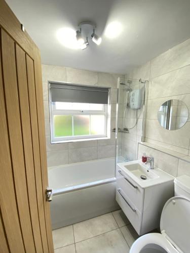 a bathroom with a tub and a sink and a toilet at Cosy Retreat In Royal Sutton Coldfield Close to Good Hope Hospital the NEC and Birmingham Airport in Birmingham