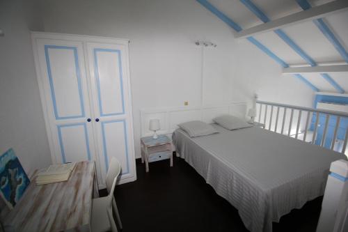 sypialnia z białym łóżkiem, stołem i stołem o wymiarach sześciu w obiekcie BlueDreamVacances Marines IV w mieście Saint-François
