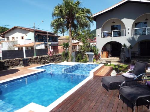 a swimming pool in front of a house at Pousada Quintal do Mar in Ubatuba