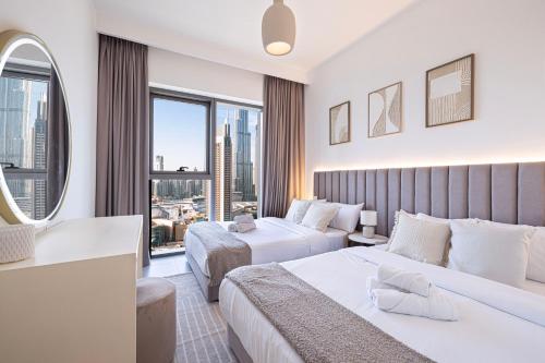 a hotel room with two beds and a large window at Burj Khalifa View, High Floor, Dubai Mall Access, Gym, Infinity-Pool, Playground, BBQ, Family Friendly in Dubai