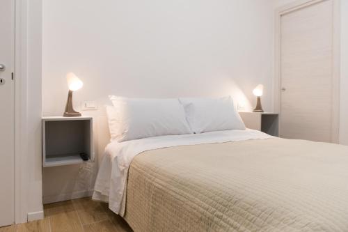 ein weißes Schlafzimmer mit einem Bett und einem TV in der Unterkunft Posterla22 in Bologna