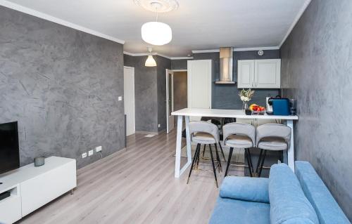 un salon avec un canapé bleu et une cuisine dans l'établissement Appartement moderne, proche du Parc de la tête d'Or et de Lyon, à Villeurbanne