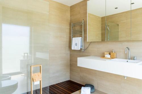 a bathroom with a sink and a mirror at Beach & Garden Apartment in Ponta Delgada