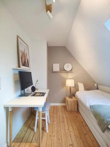 a bedroom with a bed and a desk with a computer at Leni in Wesselburen