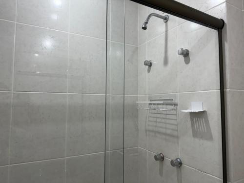 y baño con ducha y puerta de cristal. en Camboinhas Inn en Niterói