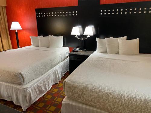 a hotel room with two beds and two lamps at Ramada by Wyndham Rochelle Park Near Paramus in Rochelle Park