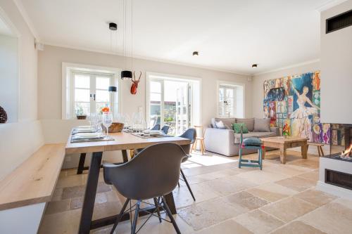 a kitchen and living room with a table and chairs at Hues Kjerte in Wenningstedt