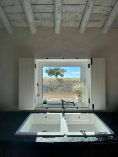 a kitchen with a large sink and a window at Monte Das 7 Oliveiras in Pias