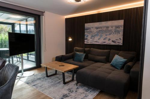 Wellness House Oase Spa mit Whirlpool في تيميندورفير ستراند: غرفة معيشة مع أريكة وتلفزيون