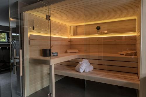 a sauna with a glass wall in a room at Wellness House Oase Spa mit Whirlpool in Timmendorfer Strand