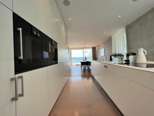 a kitchen with white cabinets and a view of the ocean at Villa am See mit privatem Seezugang in Meersburg