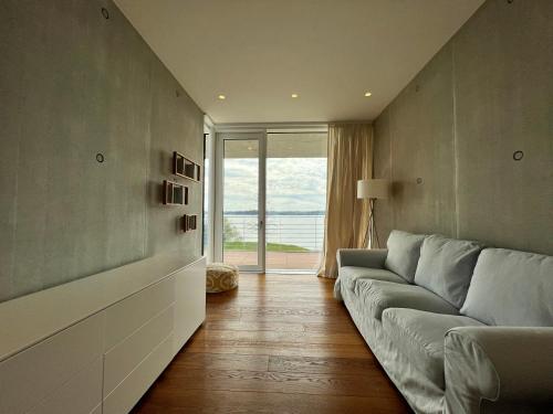 a living room with a couch and a large window at Villa am See mit privatem Seezugang in Meersburg
