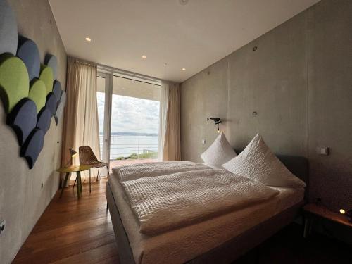 sypialnia z dużym łóżkiem i dużym oknem w obiekcie Villa am See mit privatem Seezugang w mieście Meersburg