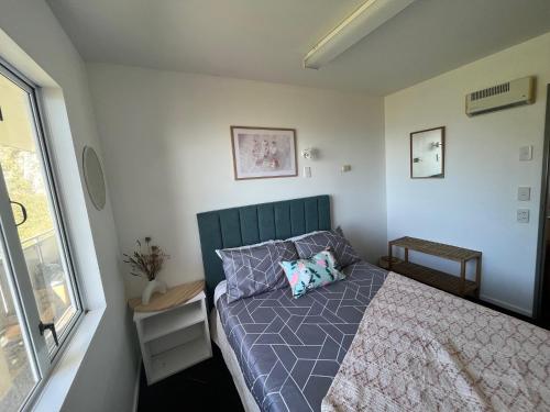 a small bedroom with a bed and a window at Kaikoura Seaside lodge in Kaikoura