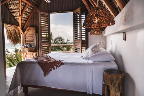 a bedroom with a bed with a view of the ocean at Casa Chula Hotel Boutique Frente al Mar in Tierra Blanca