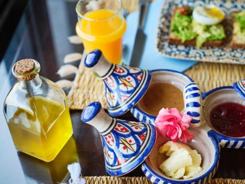 a table with two bottles of juice and a bowl of food at Dar Jasmine in Chefchaouene