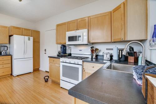a kitchen with white appliances and wooden cabinets at Pet-Friendly Saint Paul Vacation Rental with Deck! in West Saint Paul