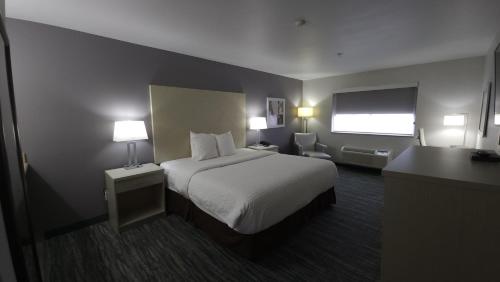 a hotel room with a bed and a television at West Valley Inn in West Valley City