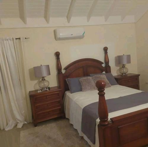 a bedroom with a bed and two night stands with lamps at Royal Palm Luxury Villas in Ocho Rios