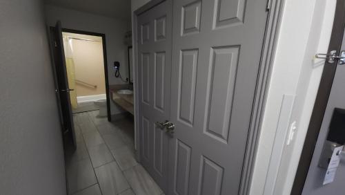 an open door to a bathroom with a toilet and a tub at West Valley Inn in West Valley City