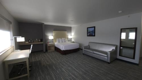 a hotel room with a bed and a couch at Best Western West Valley Inn in West Valley City