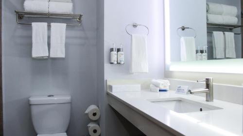 a white bathroom with a toilet and a sink at Holiday Inn Express & Suites - Ciudad Obregon by IHG in Ciudad Obregón