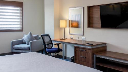 シウダード・オブレゴンにあるHoliday Inn Express & Suites - Ciudad Obregon, an IHG Hotelのデスクと椅子が備わるホテルルームです。